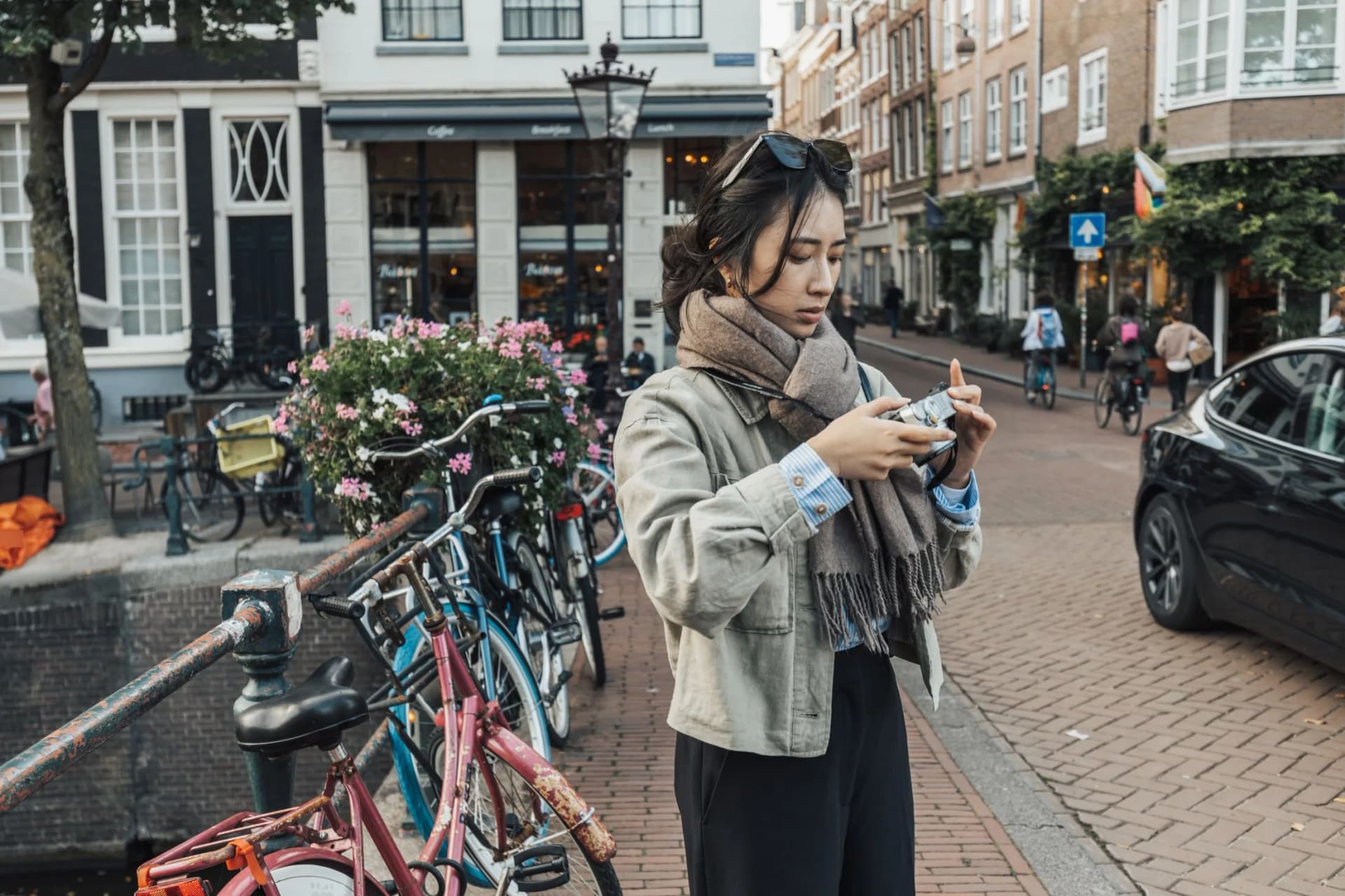Vrouw kijkt op haar telefoon aan een Amsterdamse gracht